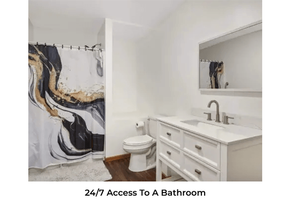 Modern bathroom with marble-patterned shower curtain and white vanity.