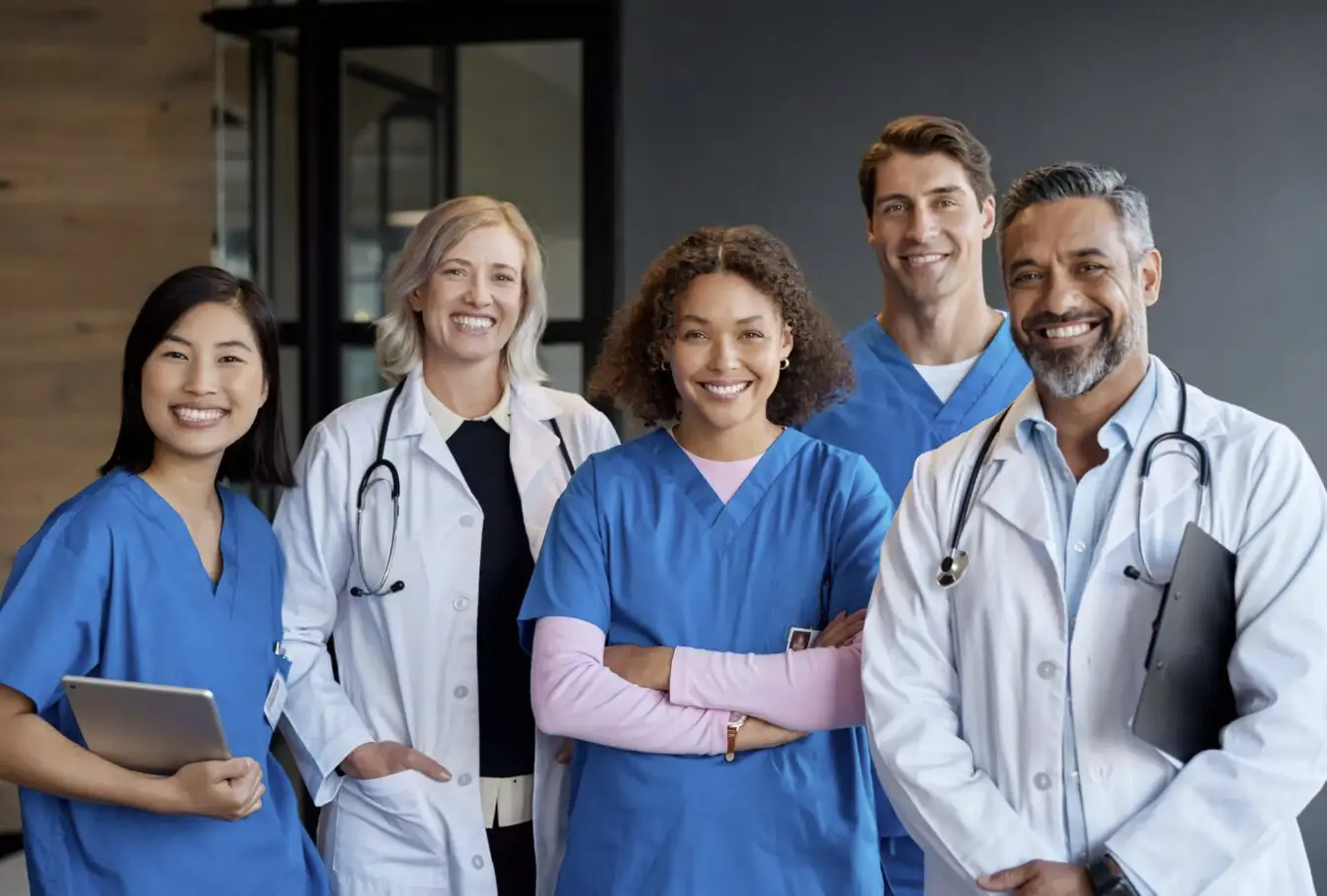 A diverse group of medical professionals smiling together.