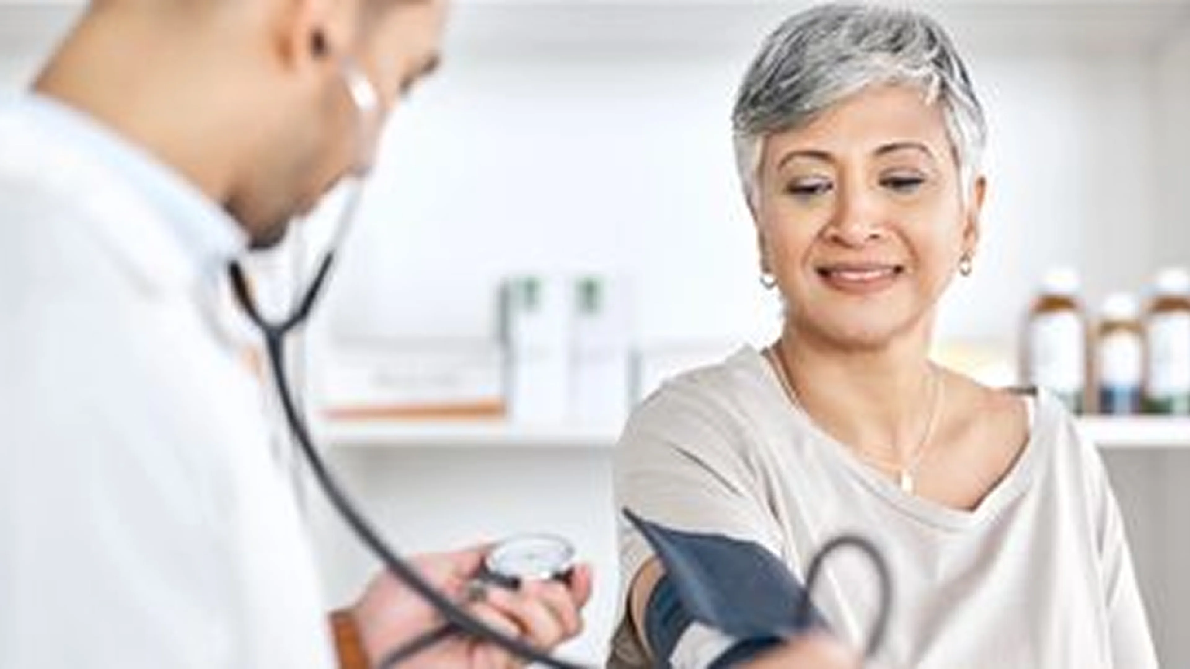Older woman having her blood pressure checked by a healthcare professional.