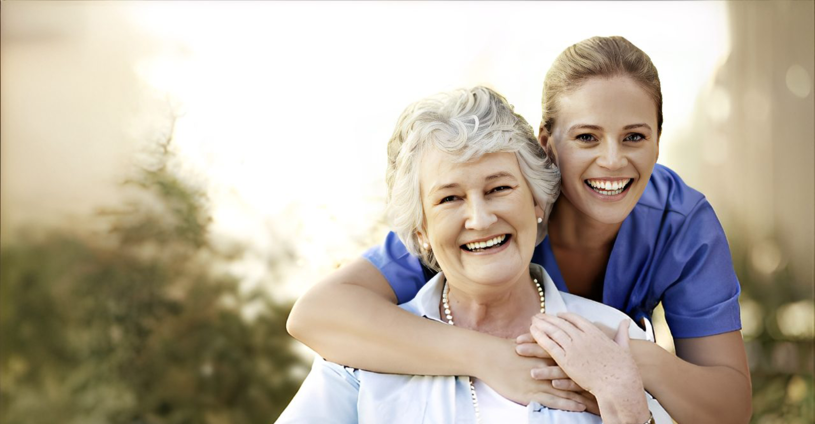 Happy elderly woman with a younger woman embracing her outdoors.